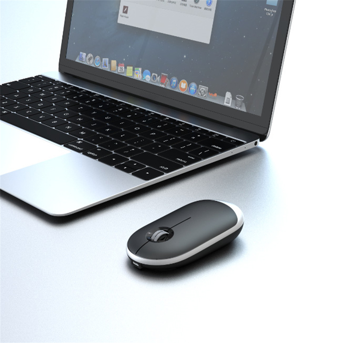 Laptop mit Maus. Die Maus ist schwarz und weiß, neben dem Laptop.