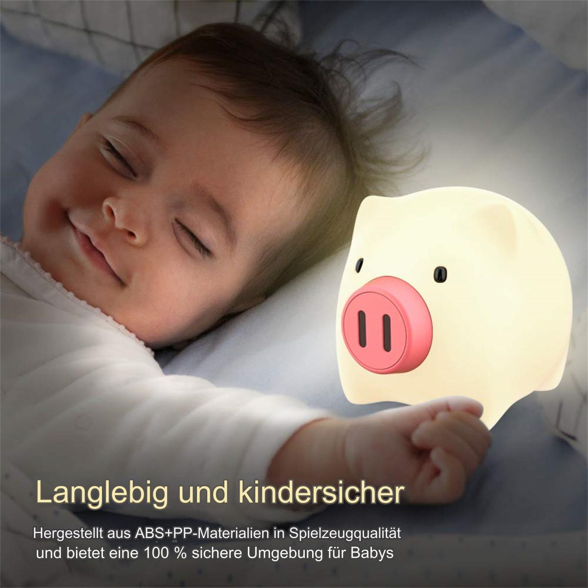 Baby schläft neben einem schweineförmigen Nachtlicht.