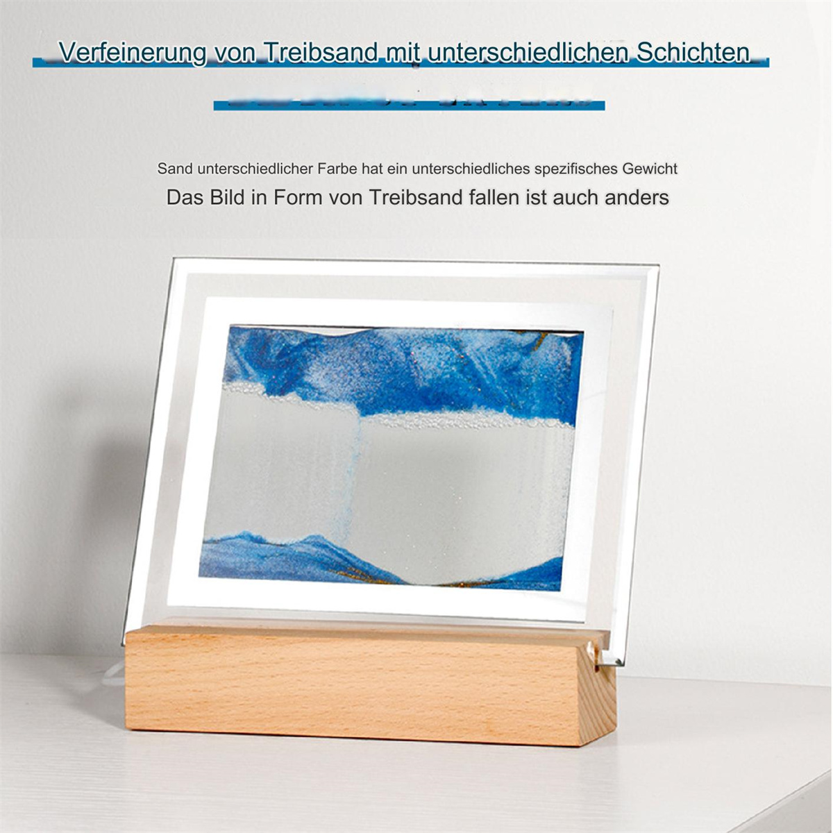 Blau-weißes Sandkunstwerk in Holzständer mit Glasrahmen.