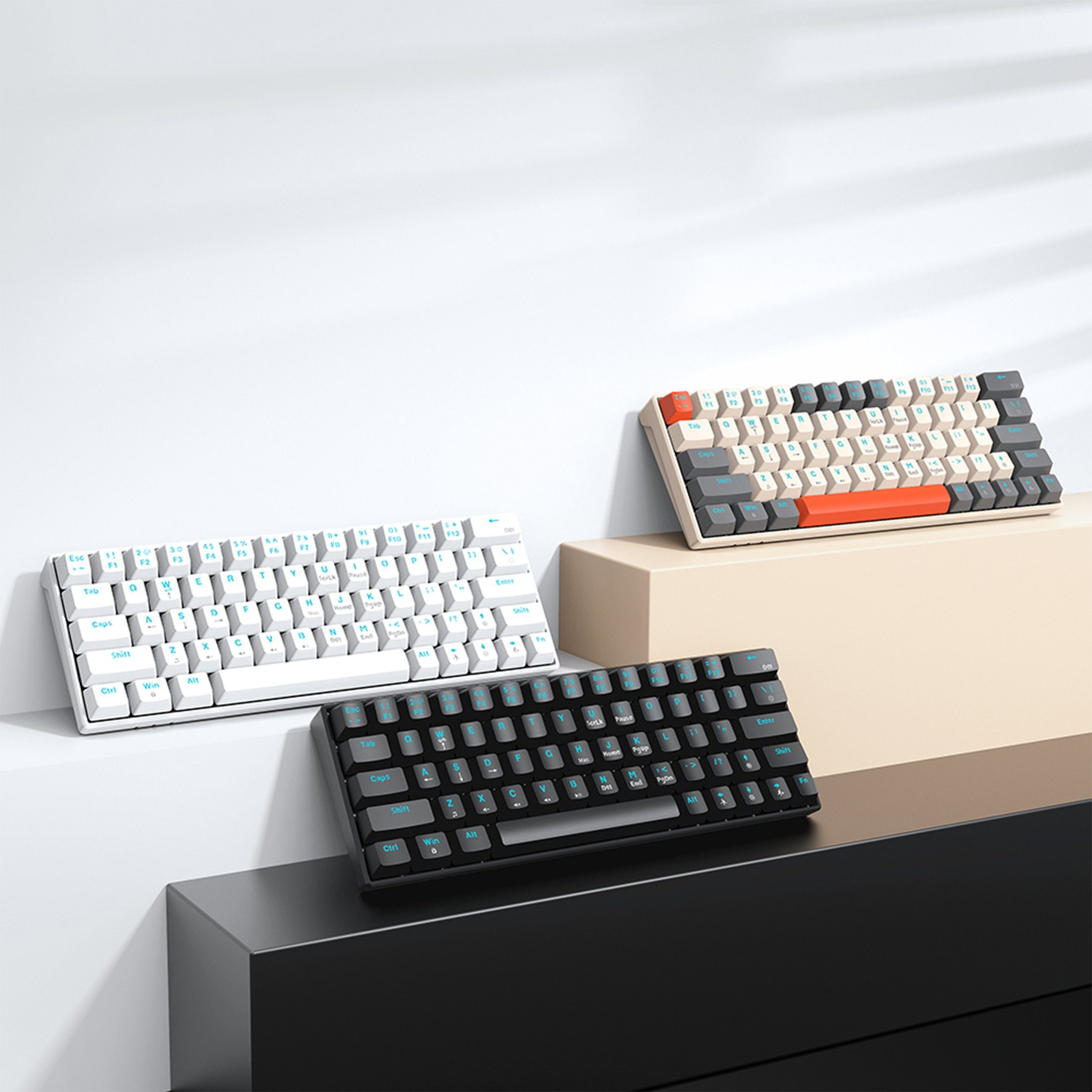 Drei Tastaturen auf verschiedenen Ebenen: weiß, beige/orange und schwarz. Weißer Hintergrund.