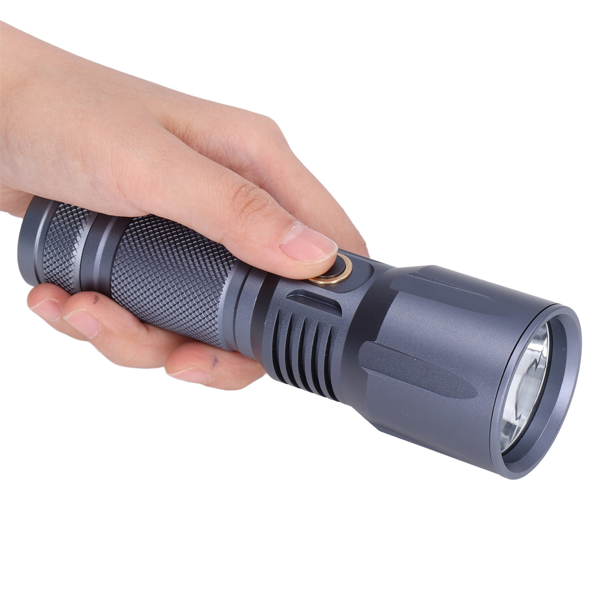 Eine Hand, die eine graue Taschenlampe mit Metallkörper und goldfarbenem Knopf hält.