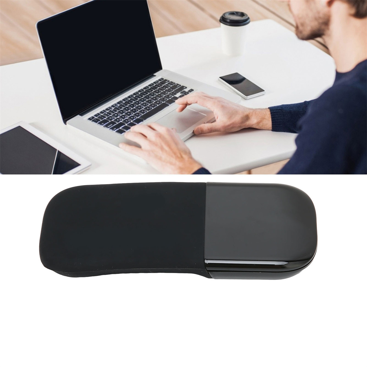 Eine Person arbeitet an einem Laptop. Ein Tablet und Telefon liegen auf dem Tisch. Eine kabellose Maus.