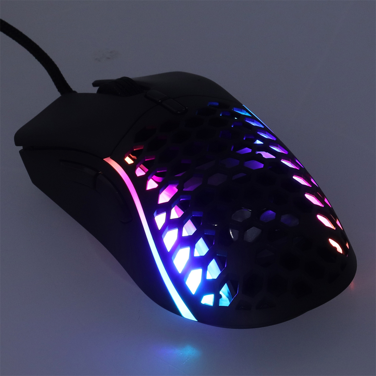 Schwarze Gaming-Maus mit RGB-Beleuchtung, Wabenmuster und Kabel.
