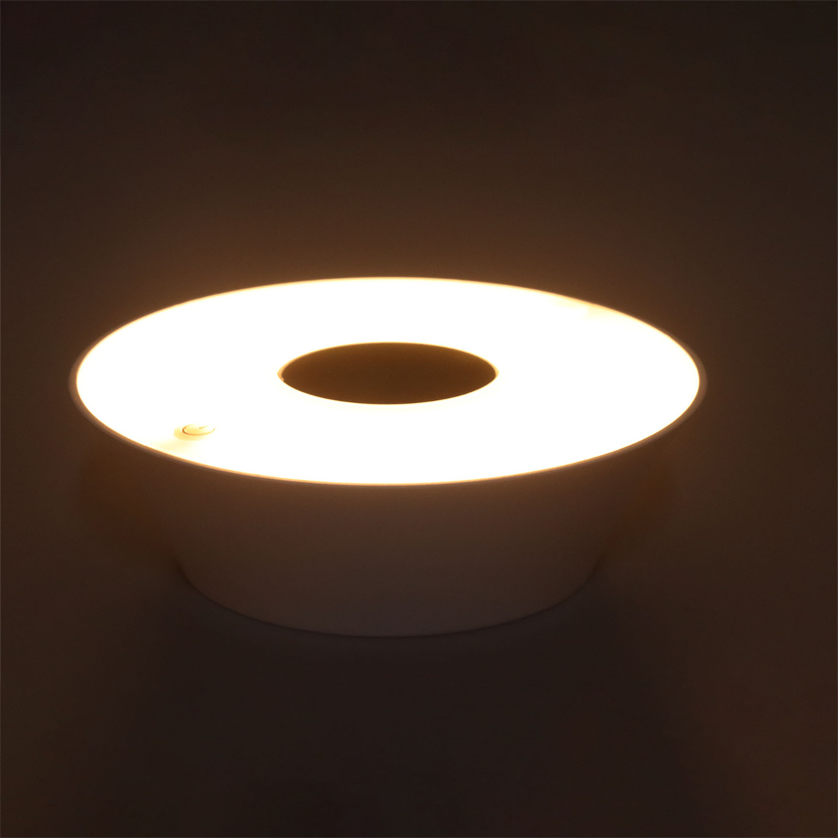 Weiße Lampe mit kreisförmiger Lichtquelle. Die Lampe ist zylindrisch mit einem Loch in der Mitte.