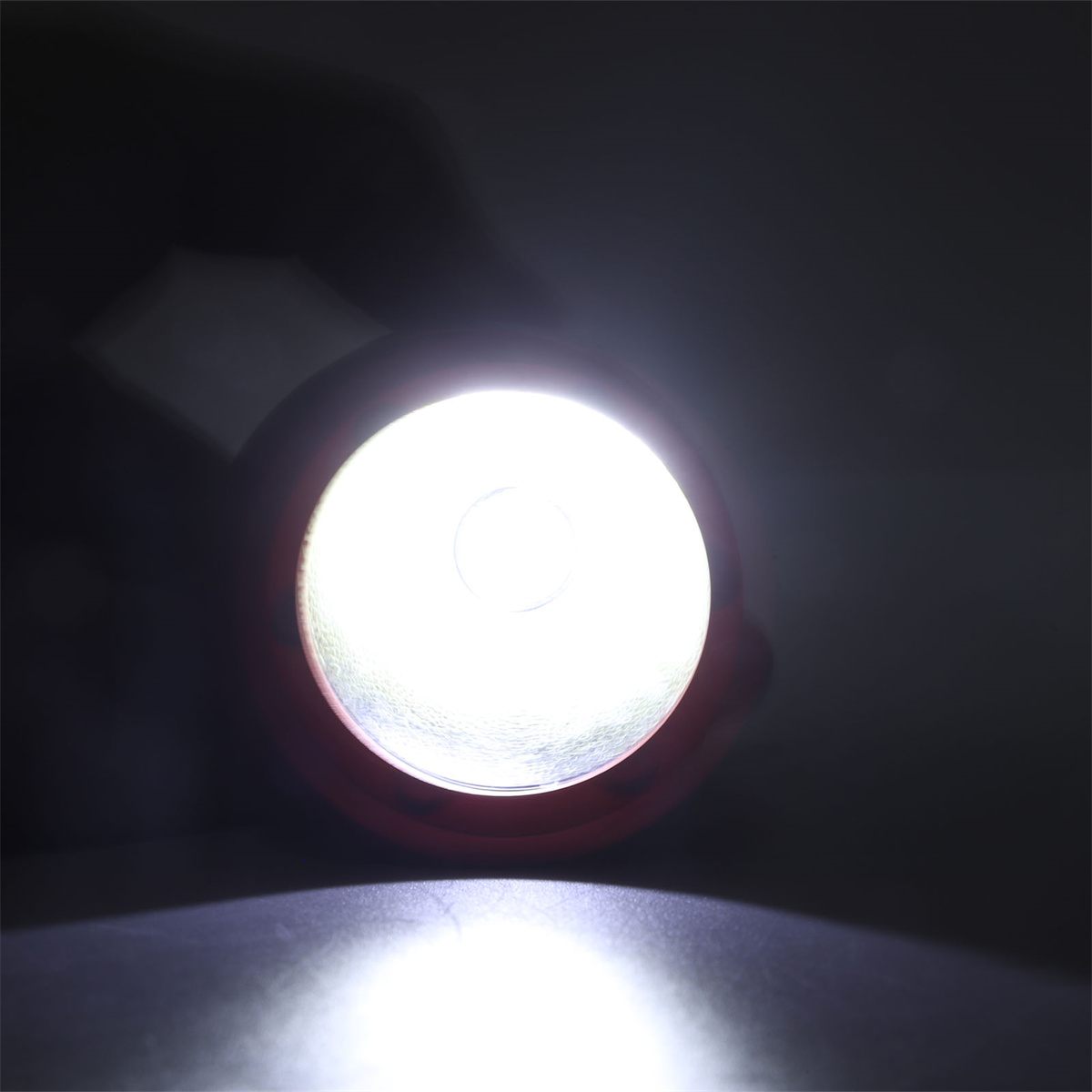 Eine Nahaufnahme einer roten Taschenlampe mit hellem Licht wird gezeigt.