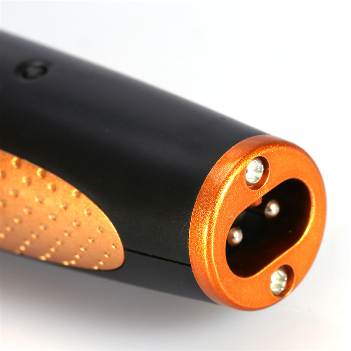Nahaufnahme eines schwarz-orangenen Elektrorasierers. Der Kopf hat drei Metallkontaktpunkte.