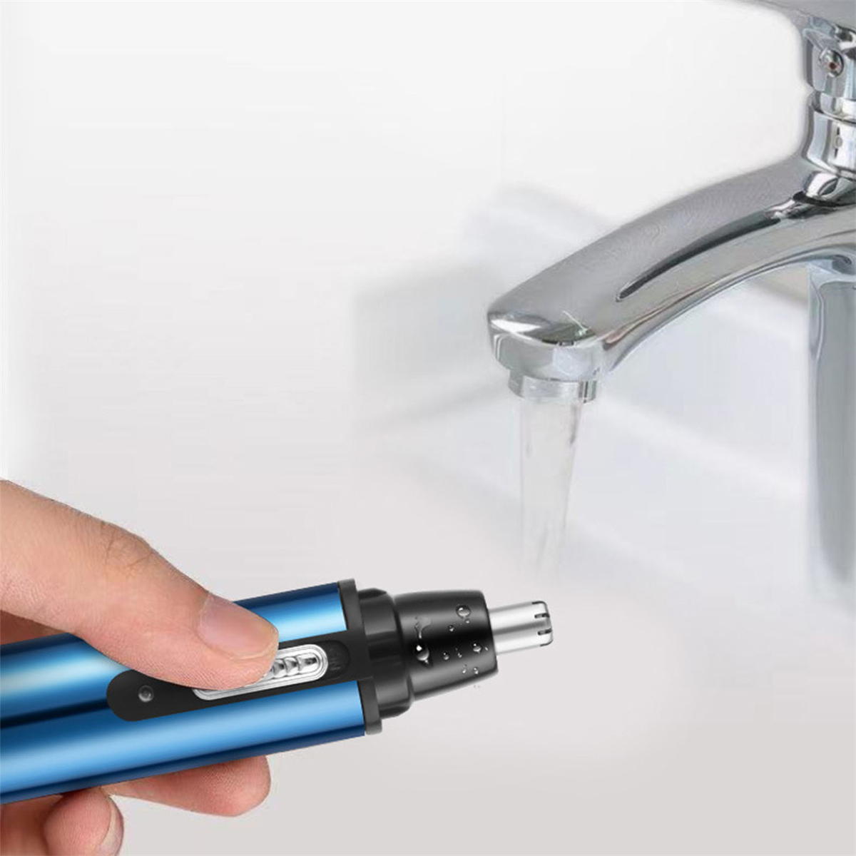 Eine Hand, die einen blau-schwarzen Nasenhaartrimmer über einem Waschbecken mit fließendem Wasser benutzt.