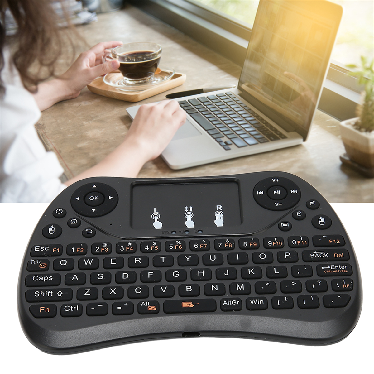 Eine schwarze Tastatur- und Maus-Kombination. Eine Person benutzt den Laptop und die Tastatur.