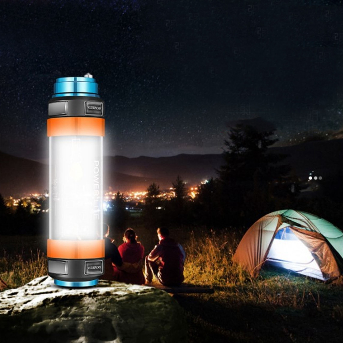 Drei Personen sitzen nachts in der Nähe eines Zeltes, beleuchtet von einer hellen, zylindrischen Taschenlampe.