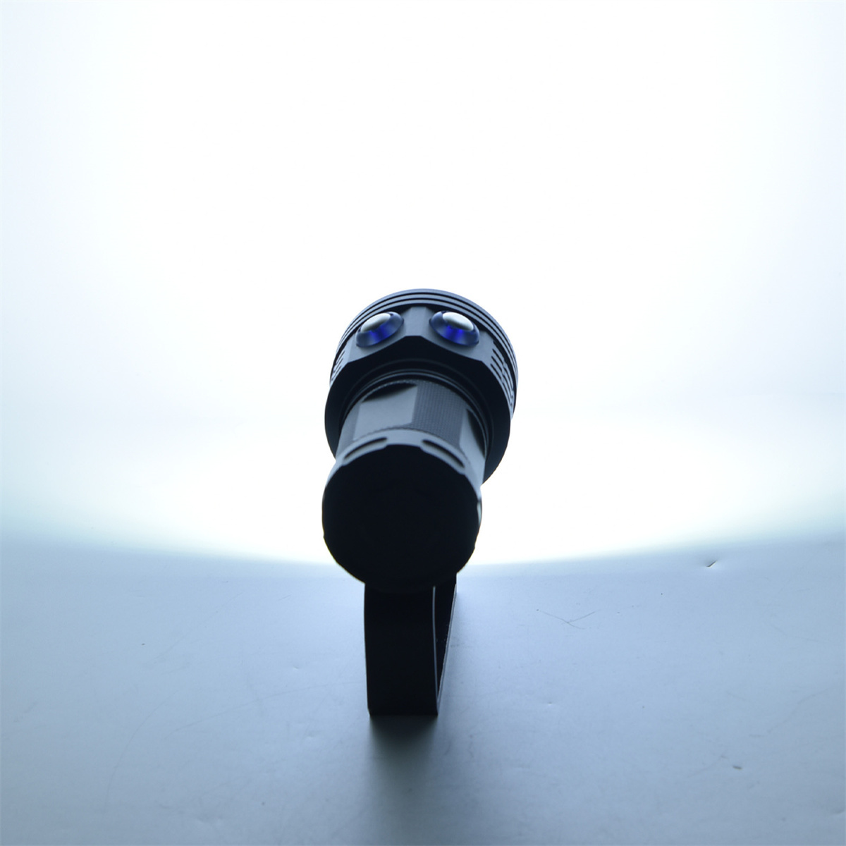 Eine schwarze Taschenlampe zeigt nach oben, wobei der Lichtstrahl leuchtet und den Hintergrund beleuchtet.