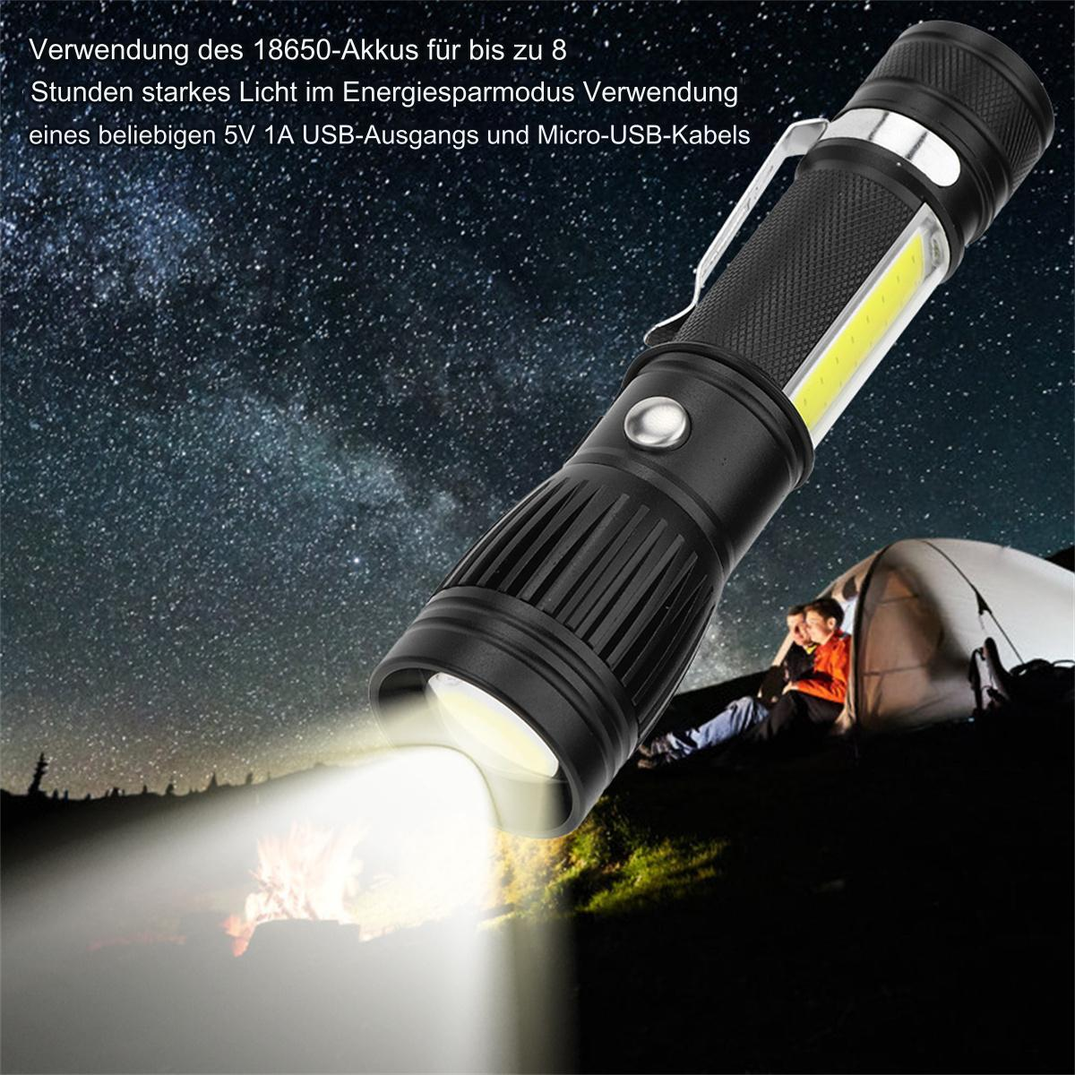 Schwarze Taschenlampe mit weißem Strahl, der auf ein Lagerfeuer scheint. Eine Person sitzt in der Nähe eines Zeltes.