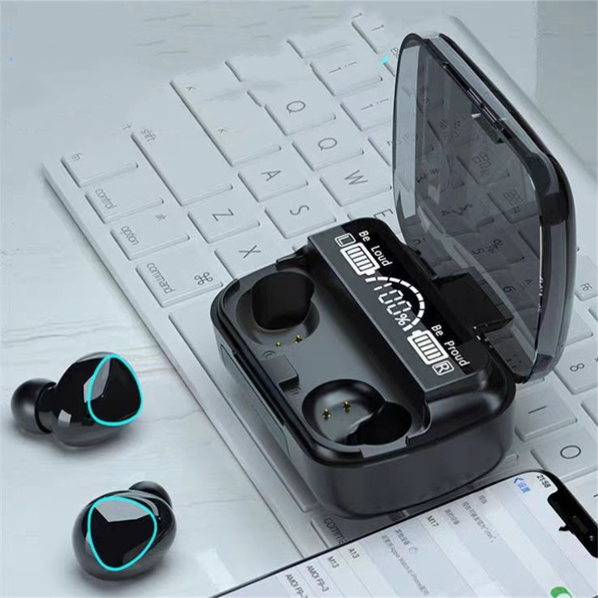 Schwarze kabellose Ohrhörer und Ladecase offen auf weißer Tastatur. Ein Telefon zeigt einen Bildschirm.