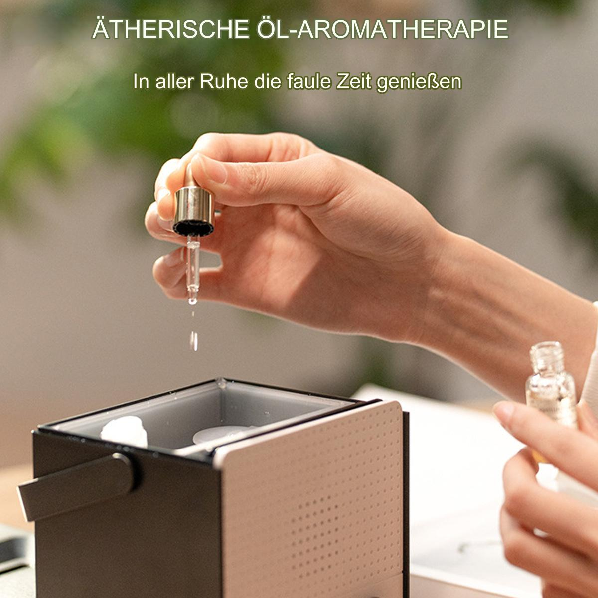 Die Hand einer Frau tropft ätherisches Öl aus einer Pipette über eine kleine Aromatherapie-Maschine. Eine Flasche ist sichtbar.