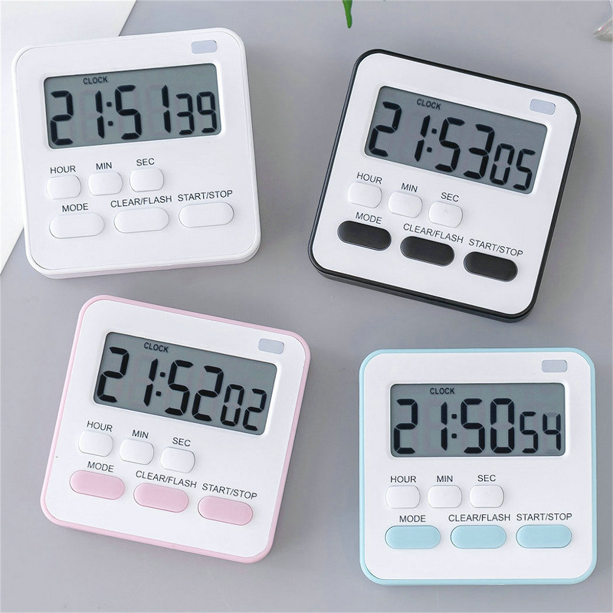Vier digitale Timer mit weißen Gehäusen und unterschiedlich farbigen Rändern, die Zeit anzeigen. Jeder hat Knöpfe und ein Display.