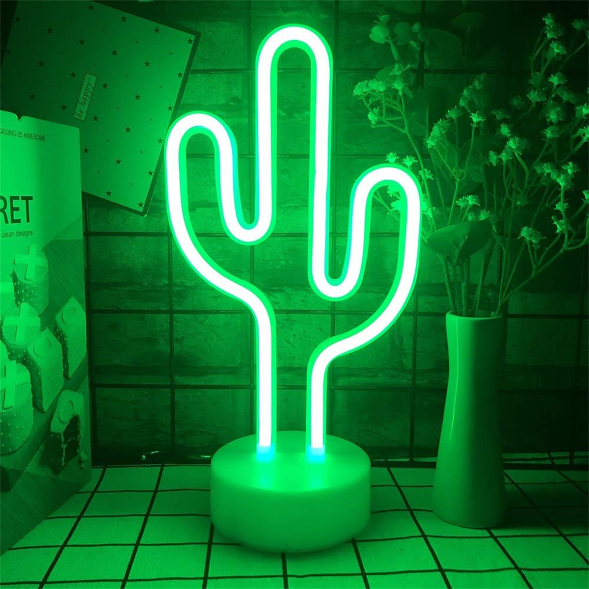 Grünes Kaktus-Neonlicht auf einem grünen Ständer, mit Blumen in einer Vase und Text im Hintergrund.