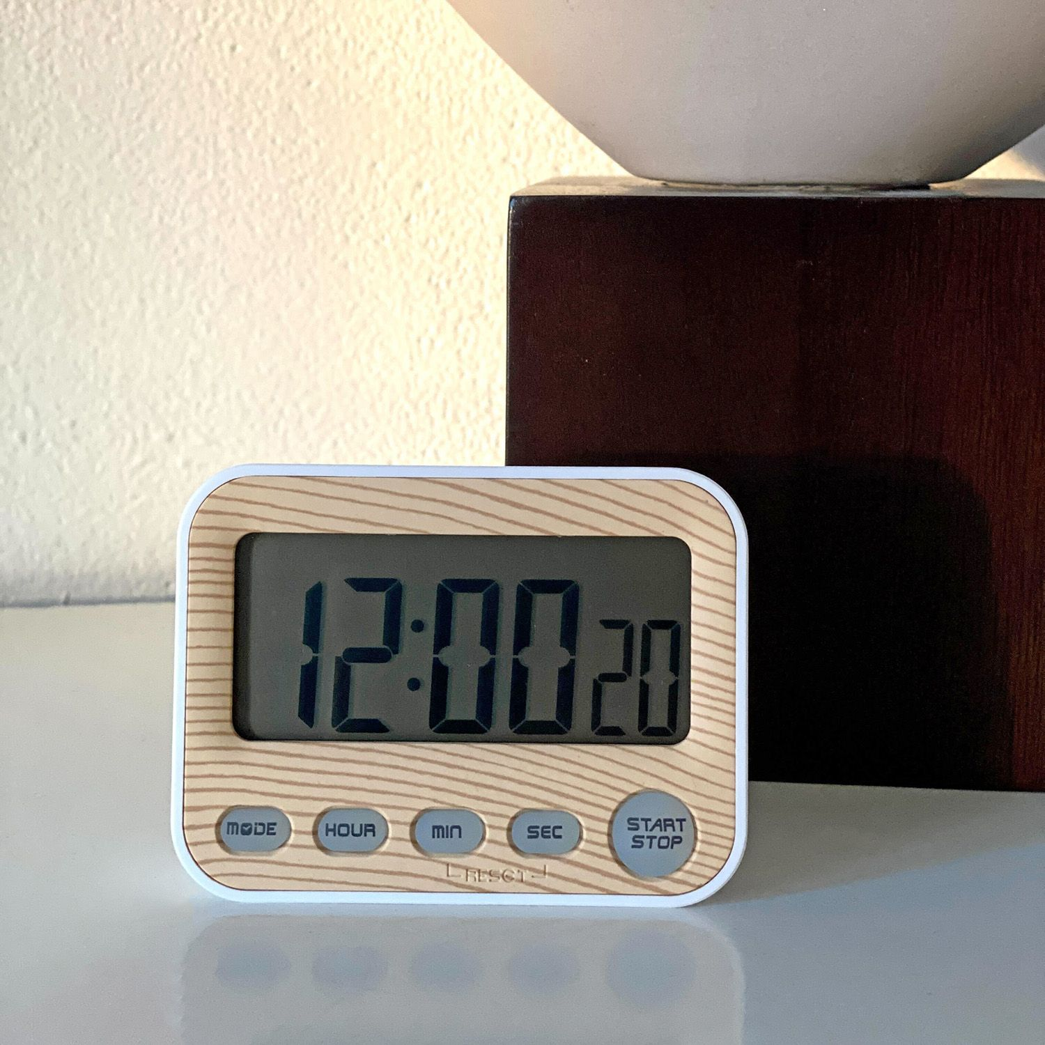 Digitaler Küchentimer mit Holzoptik, Anzeige 12:00:20. Weißer Hintergrund, modernes Design.