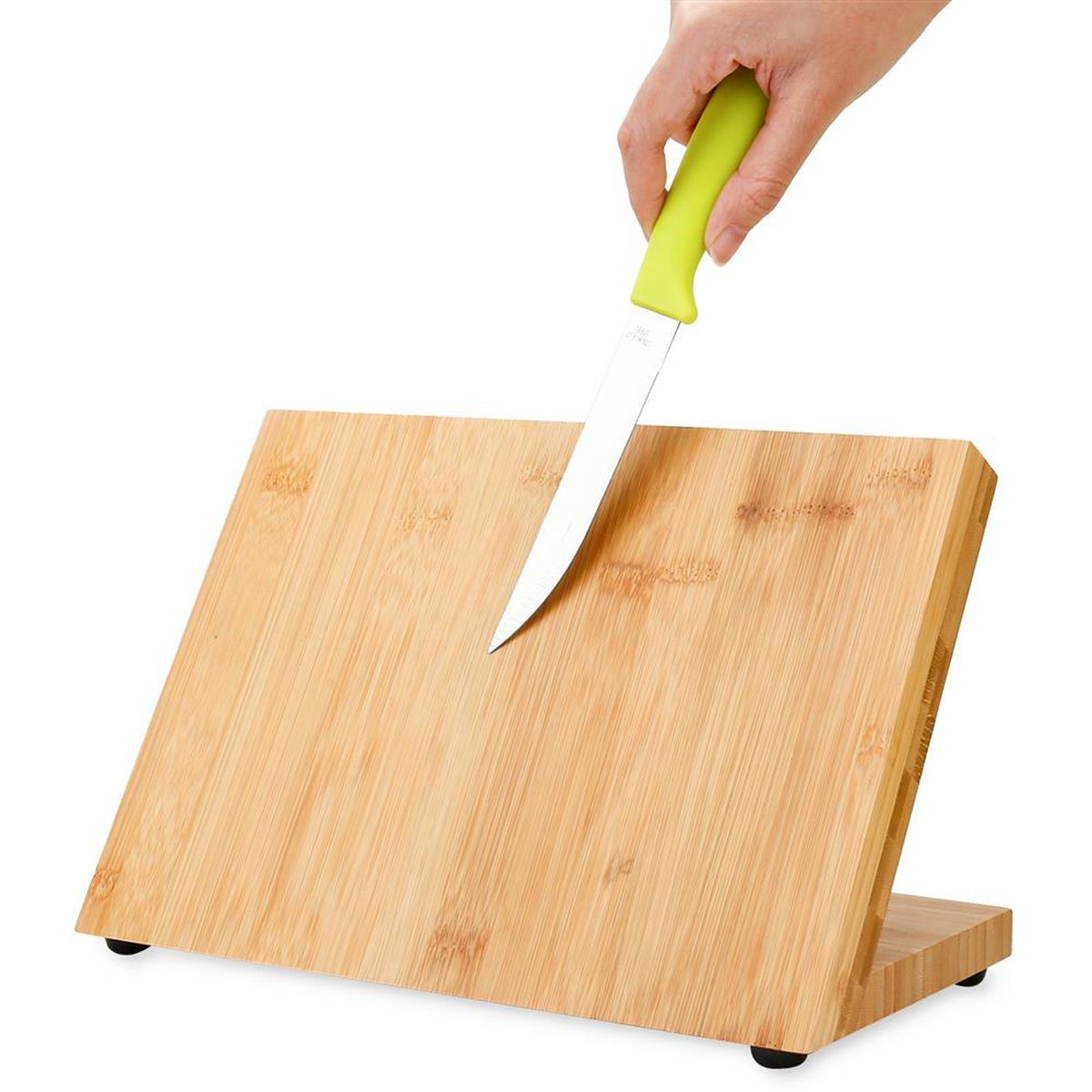 Eine Hand hält ein Messer über einem hölzernen Schneidebrett. Brett ist geneigt. Grüner Griff.