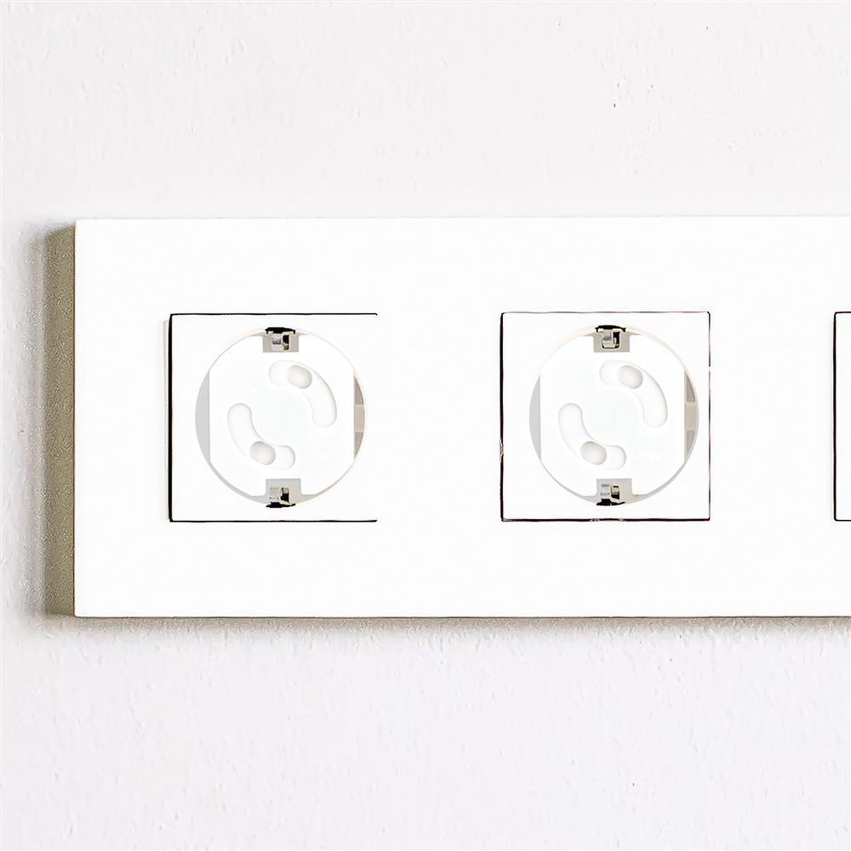 Weiße Steckdosenleiste mit drei Steckdosen. Jede Steckdose hat ein kreisförmiges Design.