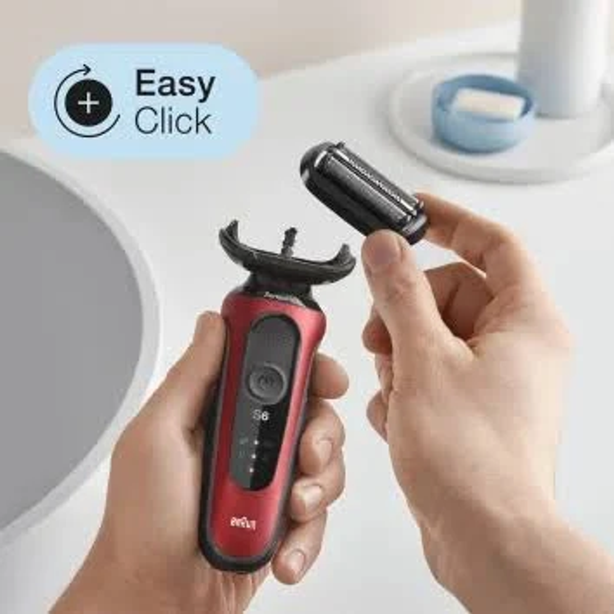 Mani che tengono un rasoio elettrico rosso e nero con testina Easy Click.