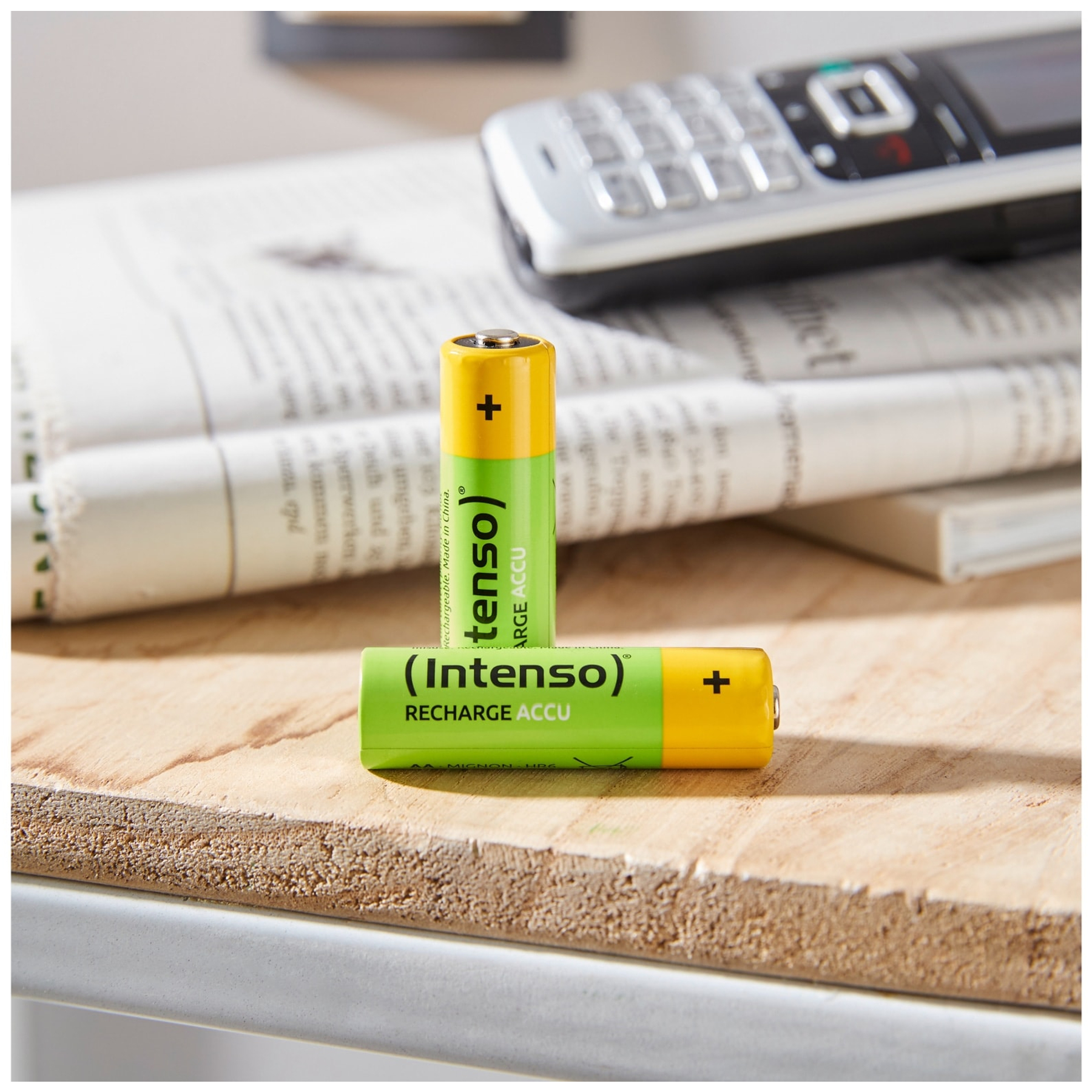 Due batterie ricaricabili verdi e gialle su una superficie di legno.