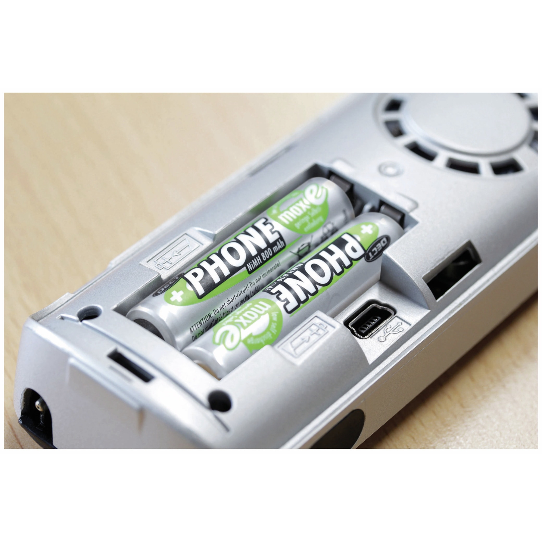 Vano aperto con due batterie AA etichettate 'PHONE maxe' e una porta USB.