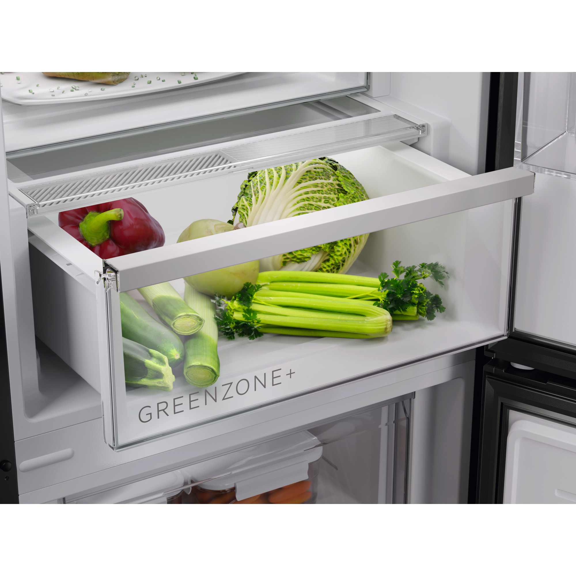 Kühlschublade voller Gemüse, darunter Paprika, Sellerie und Salat.