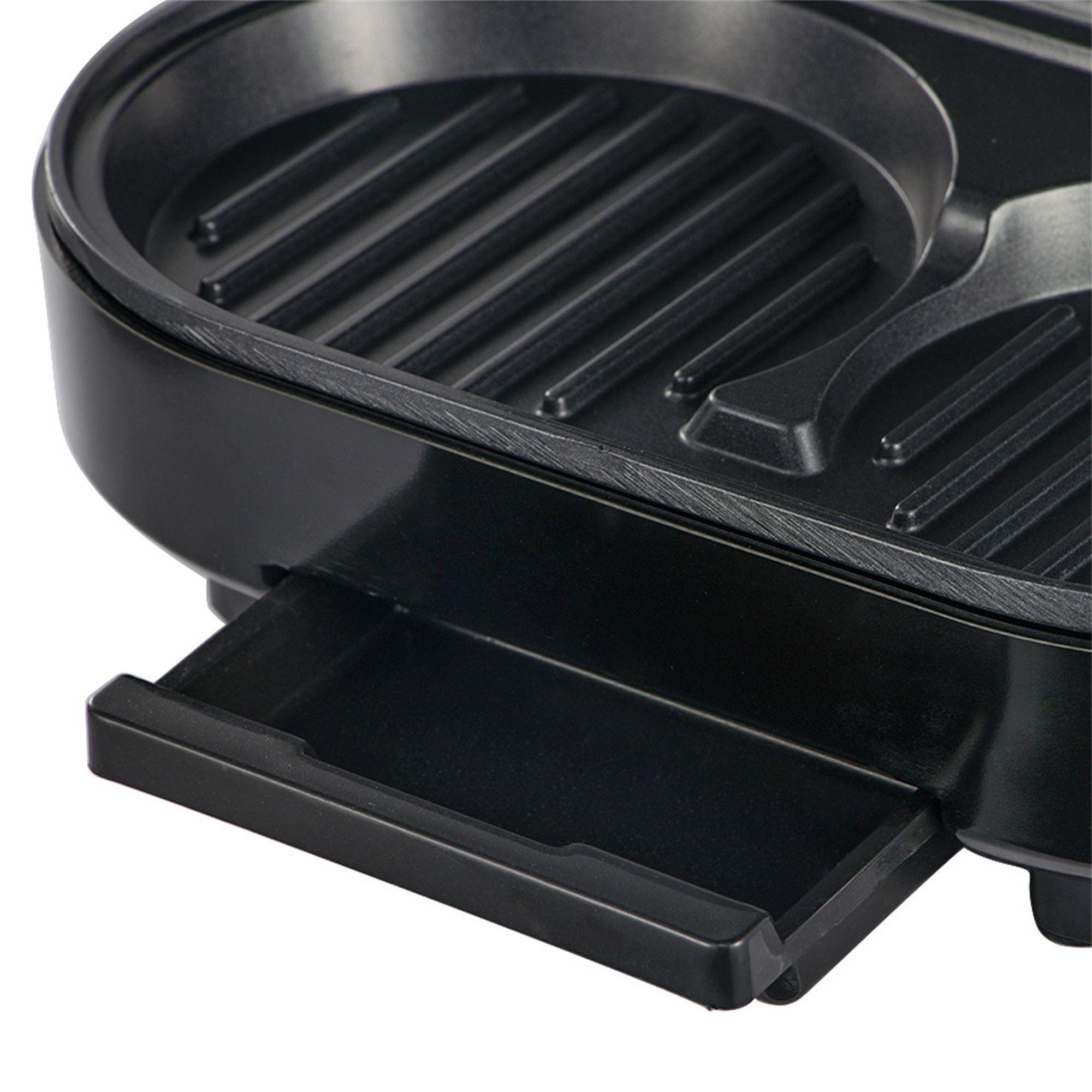 Schwarzer Elektrogrill mit herausnehmbarer Ablage. Der Grill hat Rillen auf der Kochfläche.