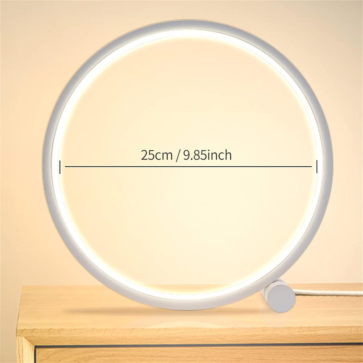 Ein weißes Ringlicht auf einem Holztisch. Es hat einen weißen Rand, und ein Netzkabel ist sichtbar.