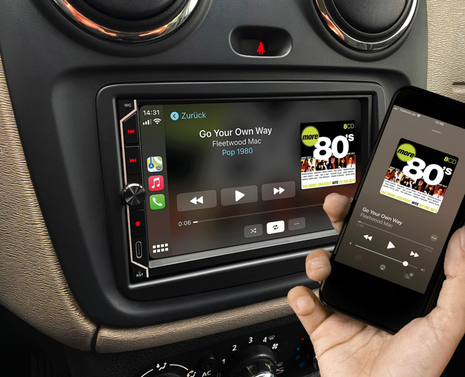 Autoradio mit einem Telefon, das Musik abspielt. Das Telefon zeigt den Song 'Go Your Own Way'.