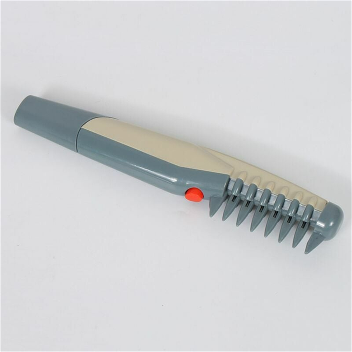 Grauer Haartrimmer mit rotem Knopf und Kamm. Weißer Hintergrund.