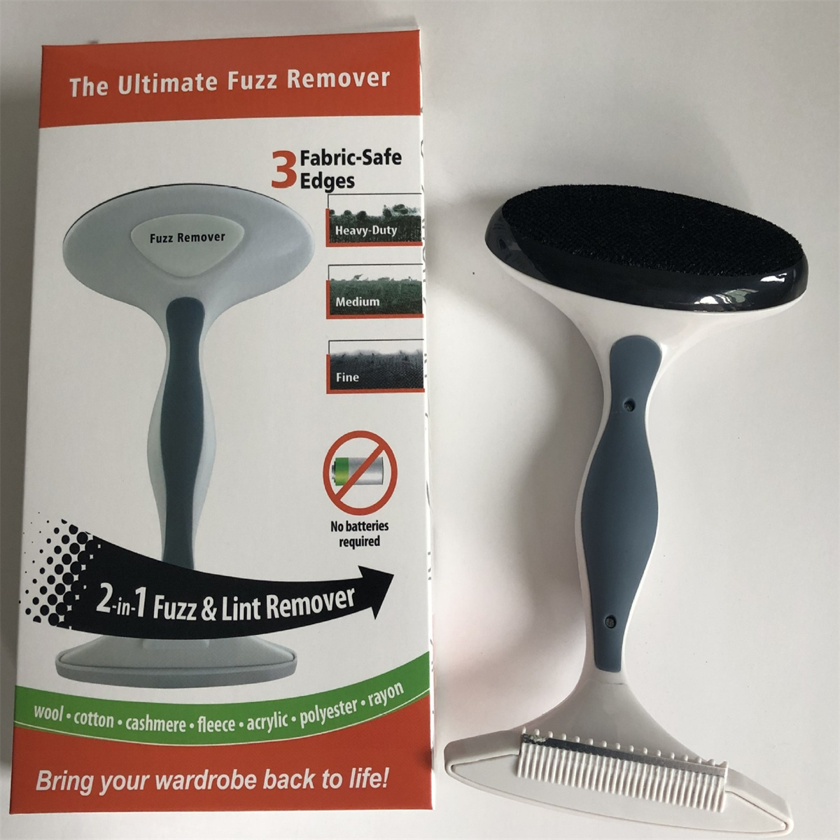 Fusselentferner-Werkzeug und seine Box. Die Box hat Text: "The Ultimate Fuzz Remover."