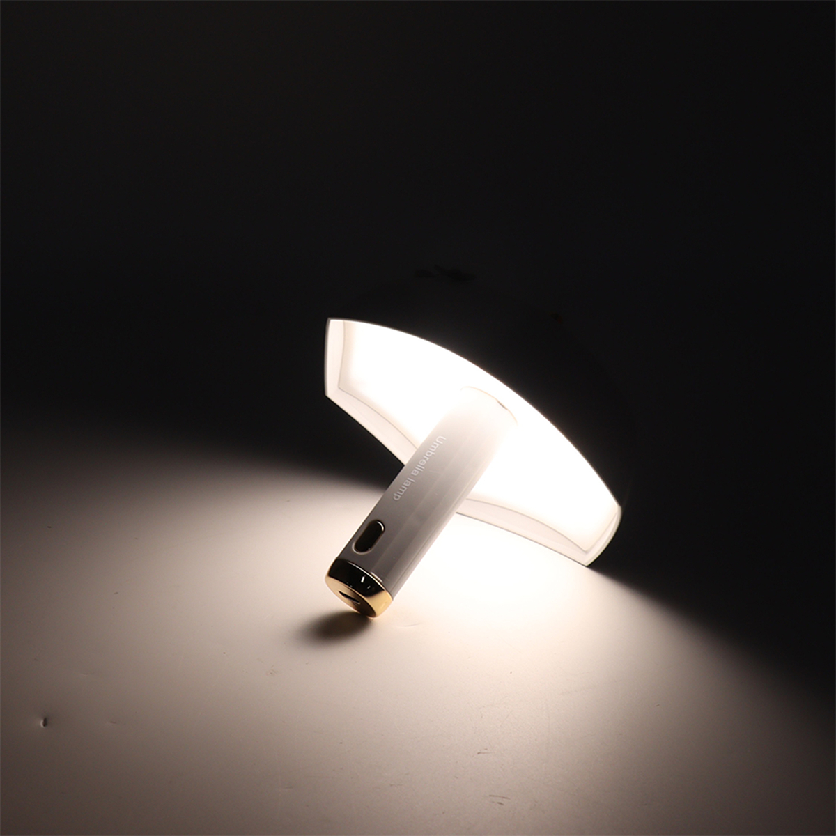 Eine weiße und graue Lampe mit goldenen Akzenten und Licht, das auf eine weiße Oberfläche scheint.