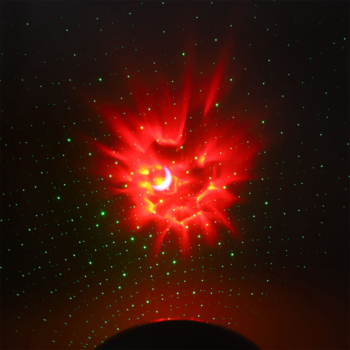Ein roter und grüner Galaxieprojektor, der Mond- und sternähnliche Muster vor dunklem Hintergrund anzeigt.