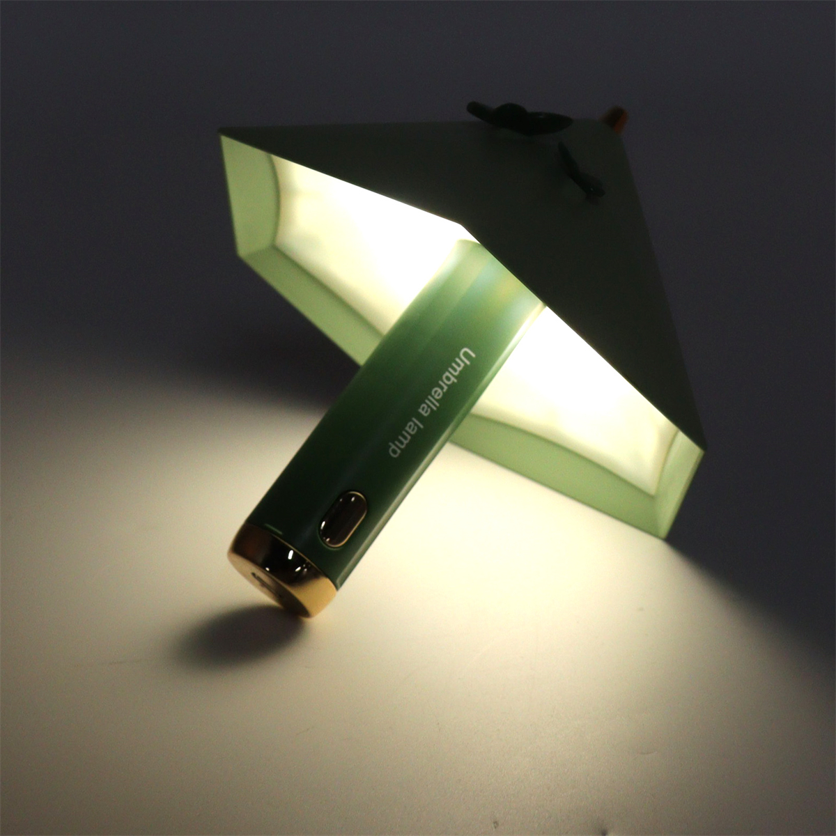Grüne schirmförmige Lampe, die Licht emittiert.