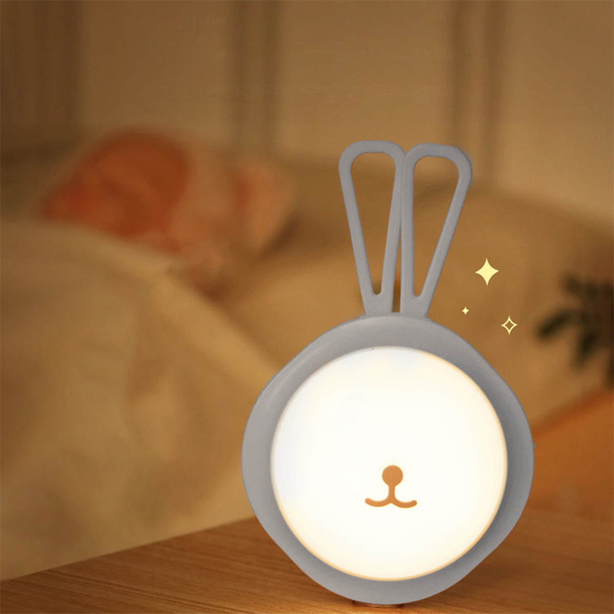 Ein hasenförmiges Nachtlicht, das auf einem Holztisch leuchtet. Sanfte Beleuchtung im Hintergrund.