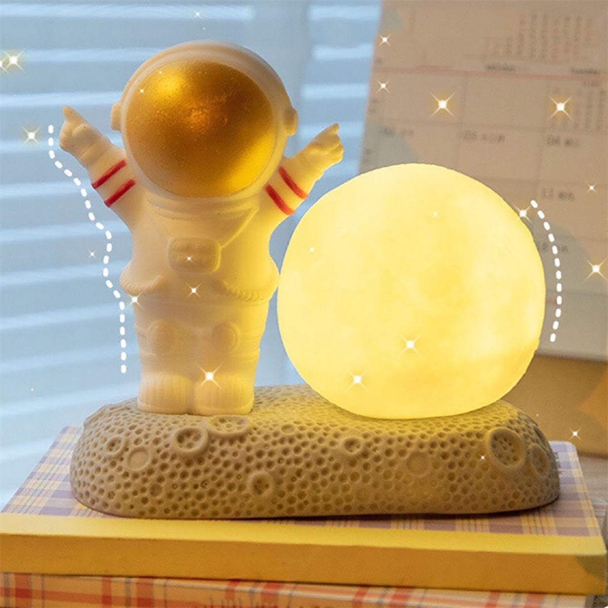 Astronautenfigur mit einer mondförmigen Lampe auf sternenklarem Hintergrund.