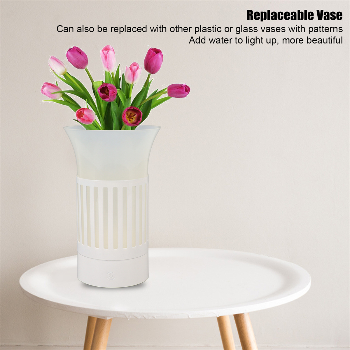 Eine weiße Vase mit rosa Tulpen auf einem Tisch. Die Vase hat ein dekoratives Muster.