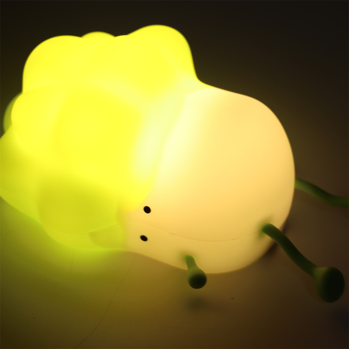 Gelb leuchtende Lampe in Form einer Schnecke.