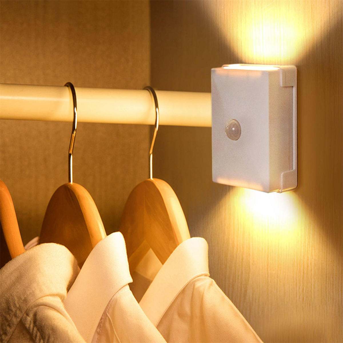 Ein weißes, bewegungssensitives Licht, das an einer Stange im Schrank befestigt ist.