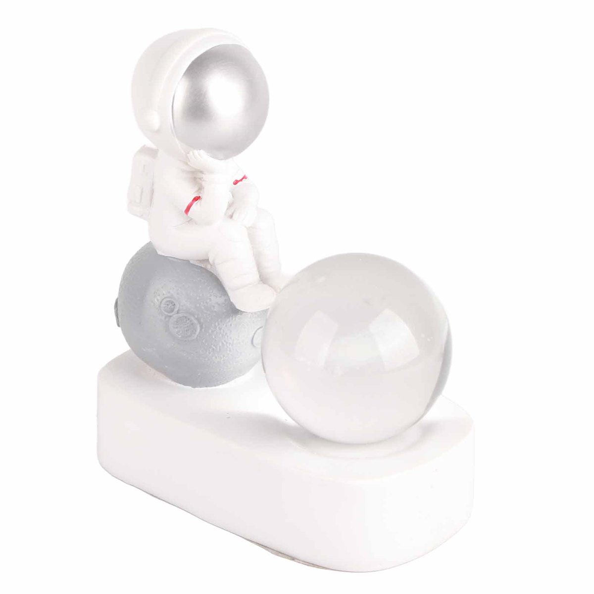 Astronautenfigur auf einem grauen Mond mit einer klaren Kugel daneben, auf einer weißen Plattform.