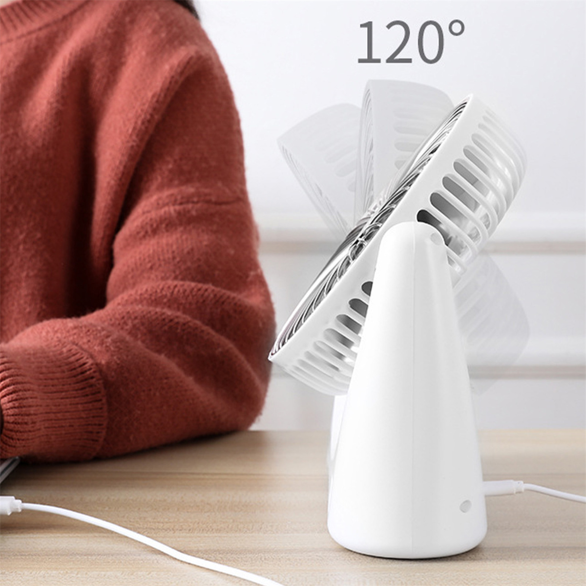 Ein weißer Ventilator mit einstellbarem Winkel, 120 Grad, auf einem Holztisch.