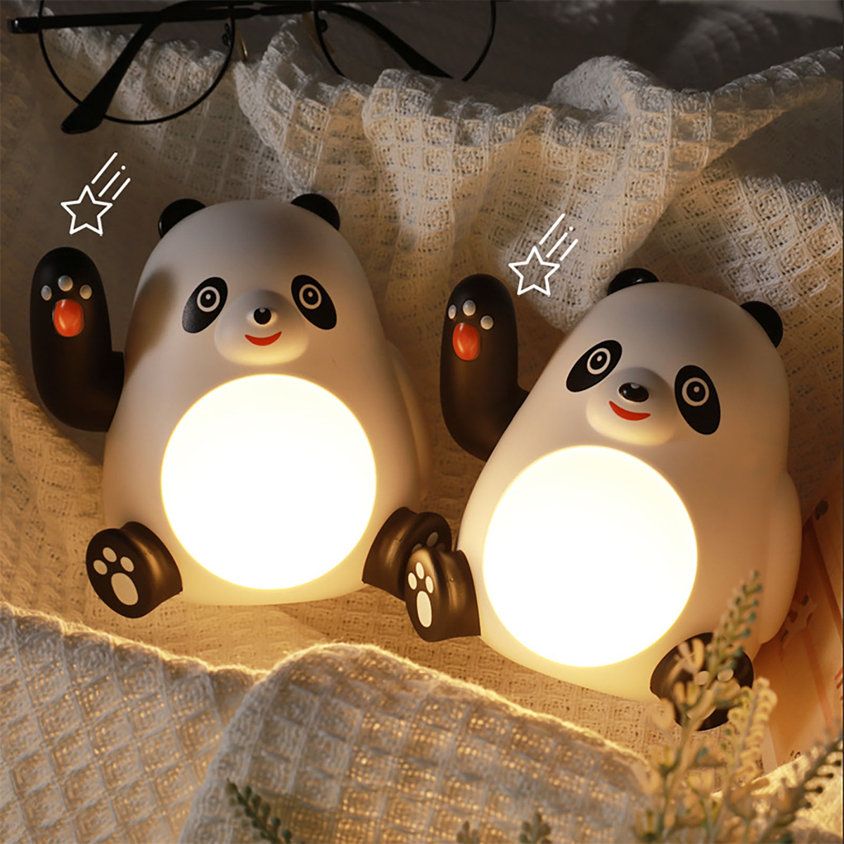 Zwei panda-förmige Lampen leuchten, auf einer Decke sitzend, mit einer Brille.
