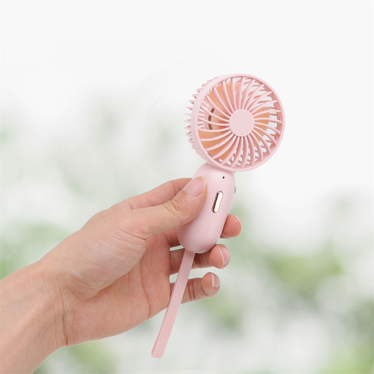 Pinker Handventilator, der von einer Hand gehalten wird, mit hellem Hintergrund.