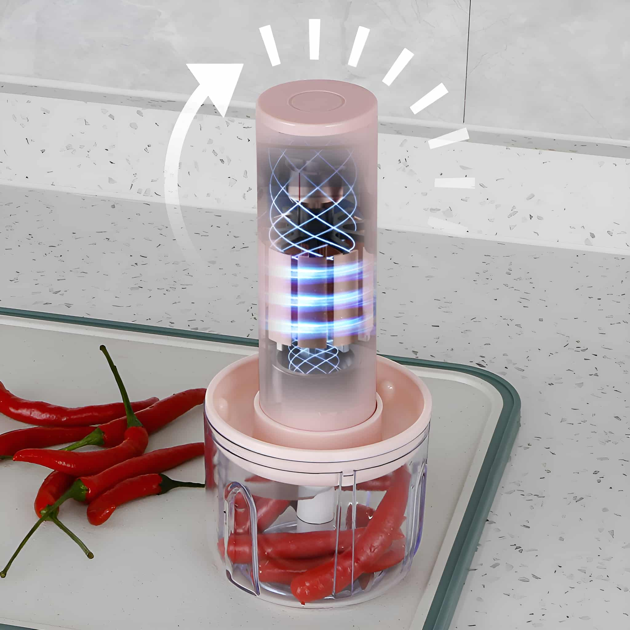 Ein rosa und klarer Foodprocessor mit roten Chilischoten auf einer weißen Oberfläche.