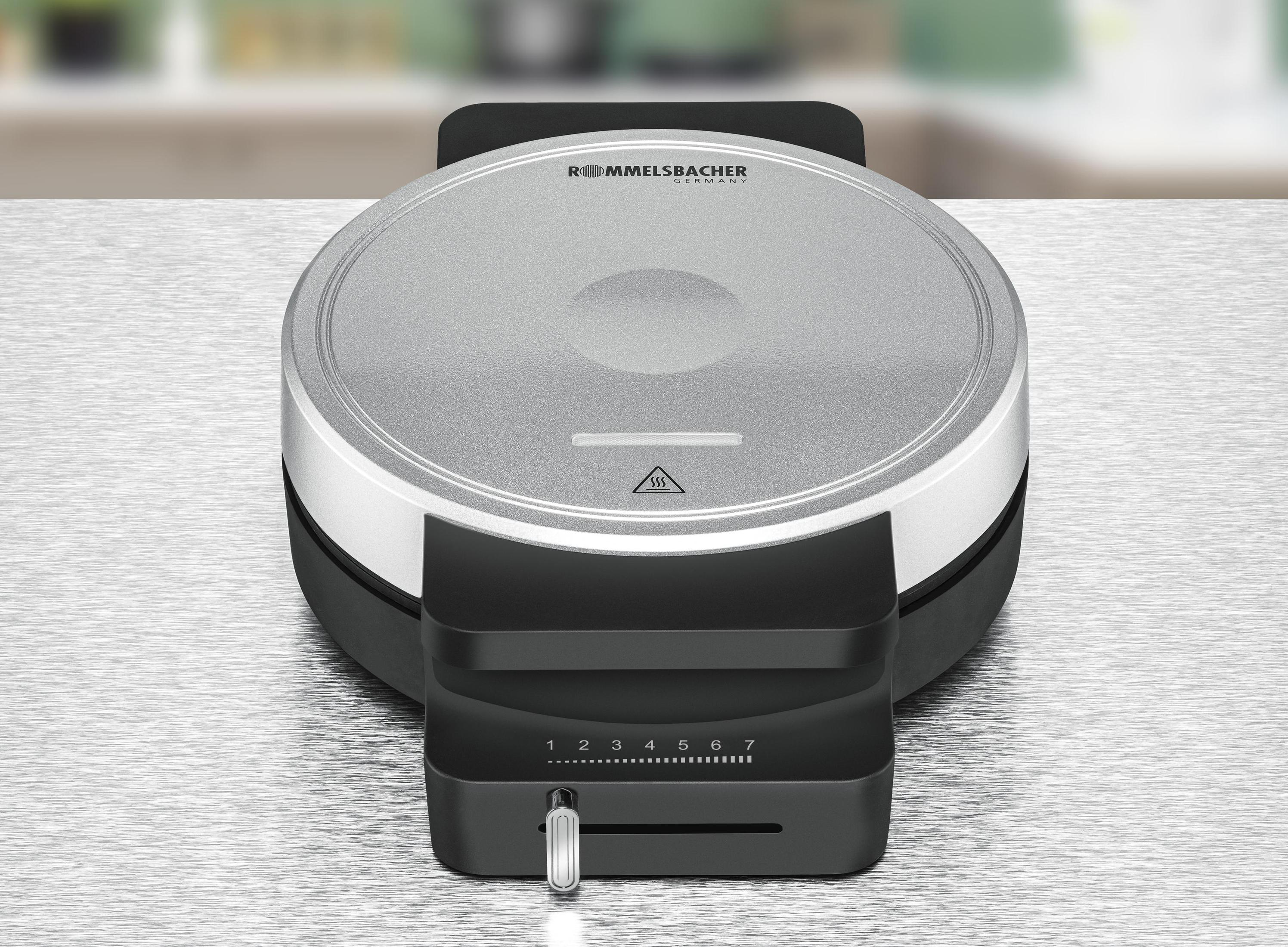 Gofrownica na stole. Górna część jest otwarta, a pokrętło jest widoczne. Tło jest rozmyte.