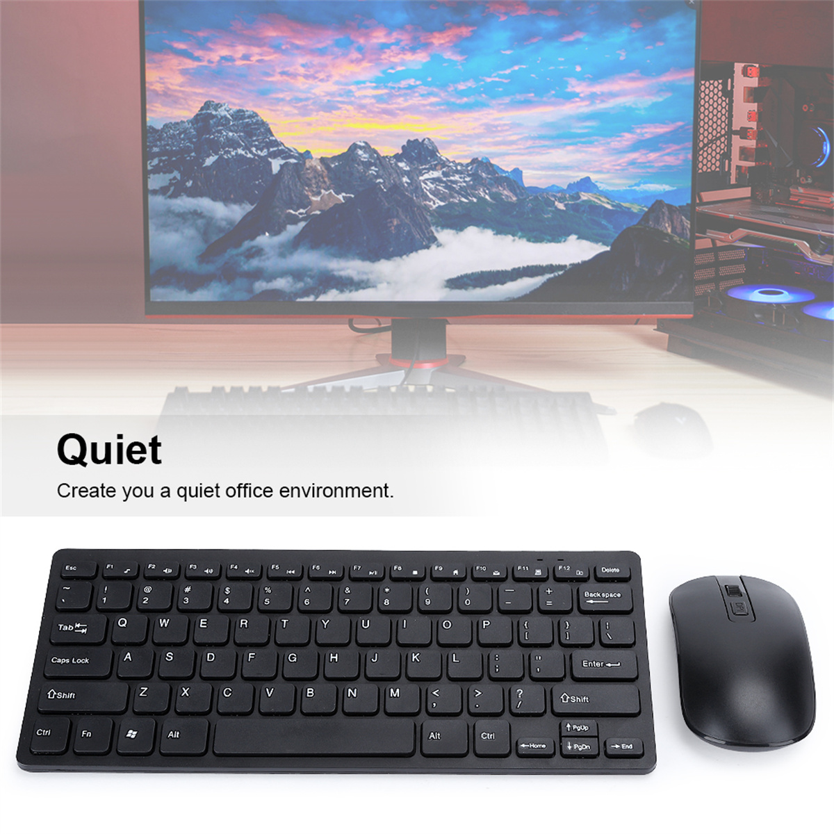Ein schwarzes Tastatur- und Maus-Set auf einem Schreibtisch. Ein Computermonitor zeigt eine Berglandschaft im Hintergrund.