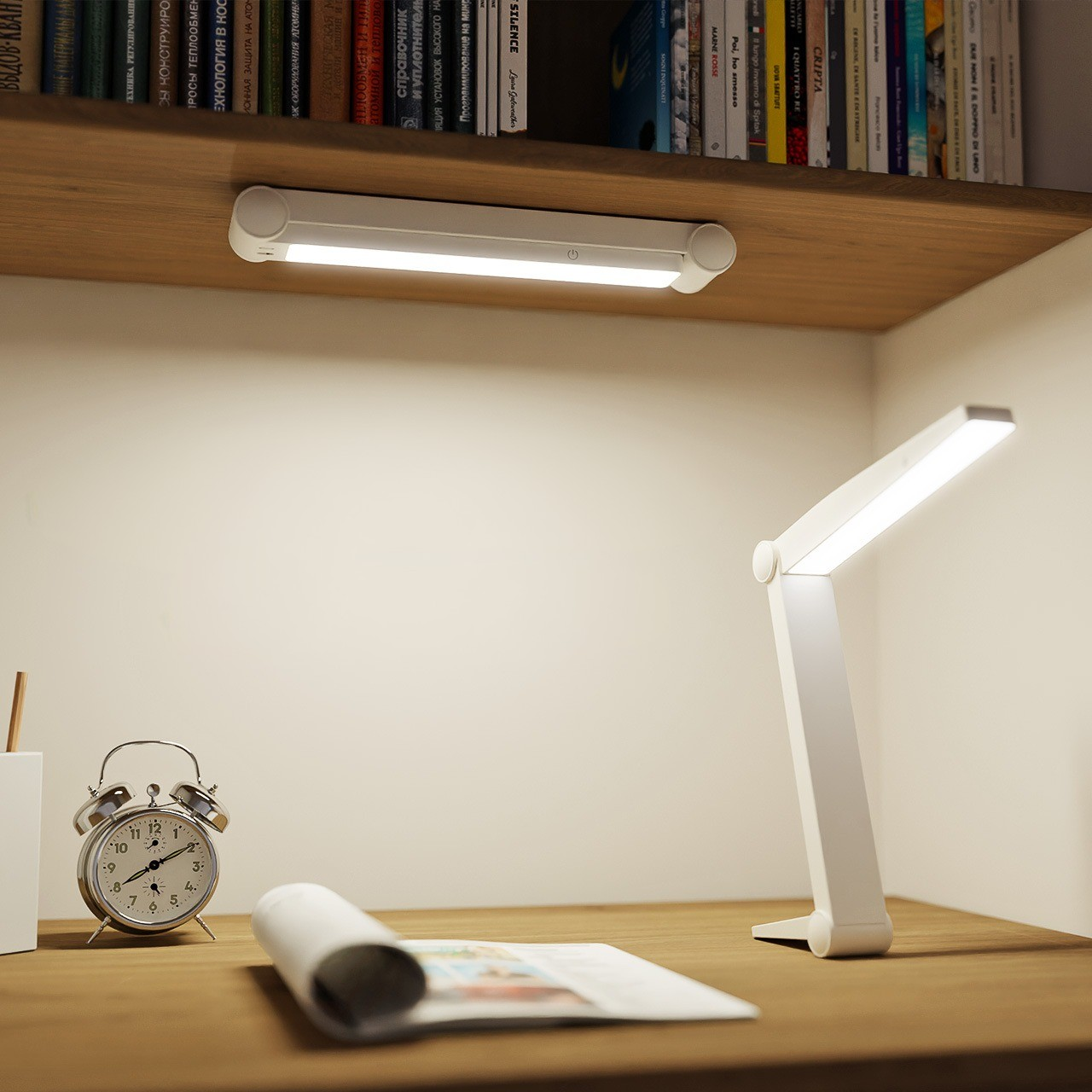 Schreibtisch mit weißer Lampe, Tischlampe, Uhr und gerolltem Papier. Ein Regal mit Büchern ist oben.