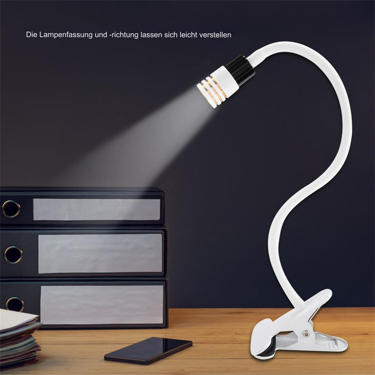 Eine weiße Schreibtischlampe mit flexiblem Hals, die Licht auf einen Schreibtisch mit Telefon und schwarzen Akten wirft.