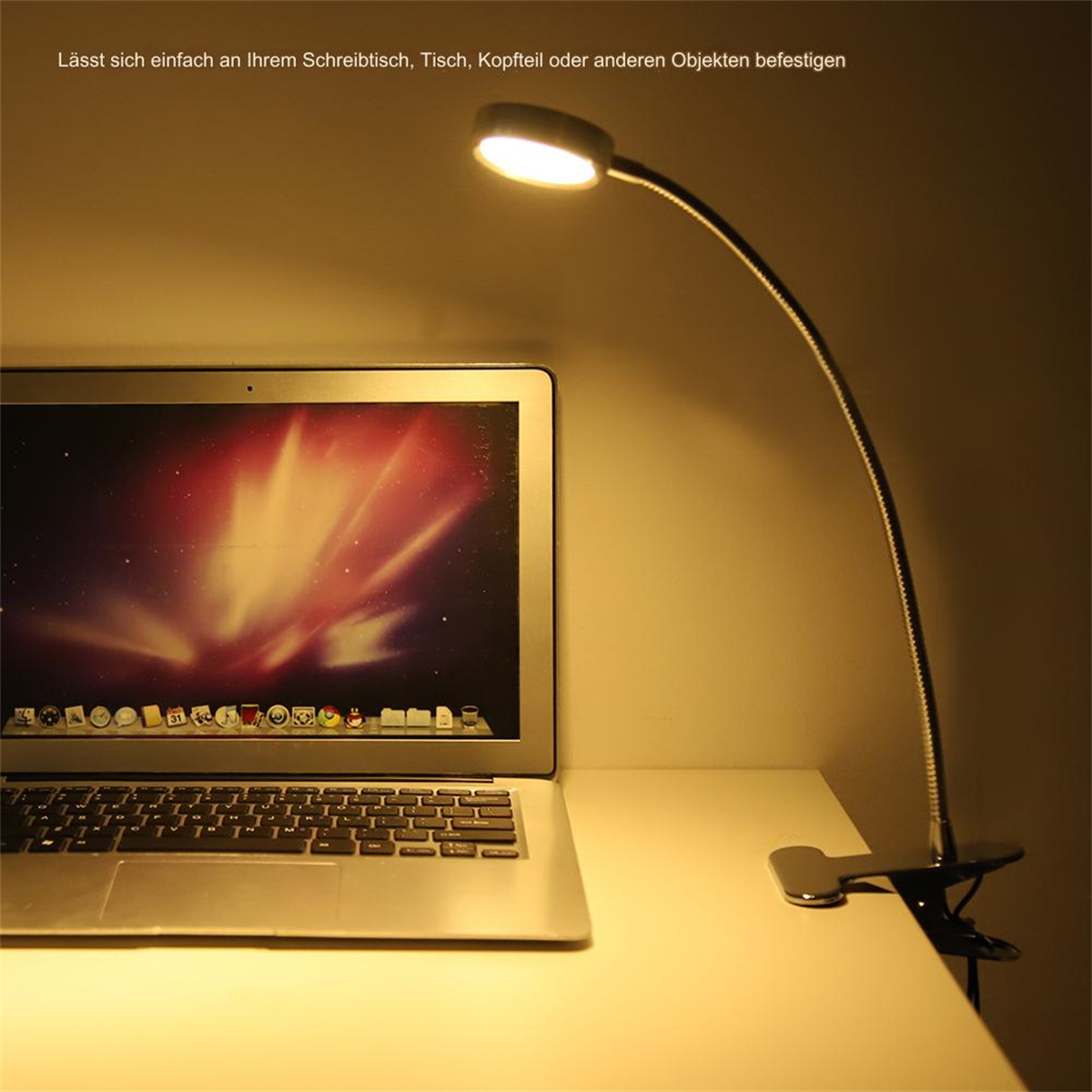 Eine Schreibtischlampe auf einem Schreibtisch, die einen Laptop-Bildschirm beleuchtet.