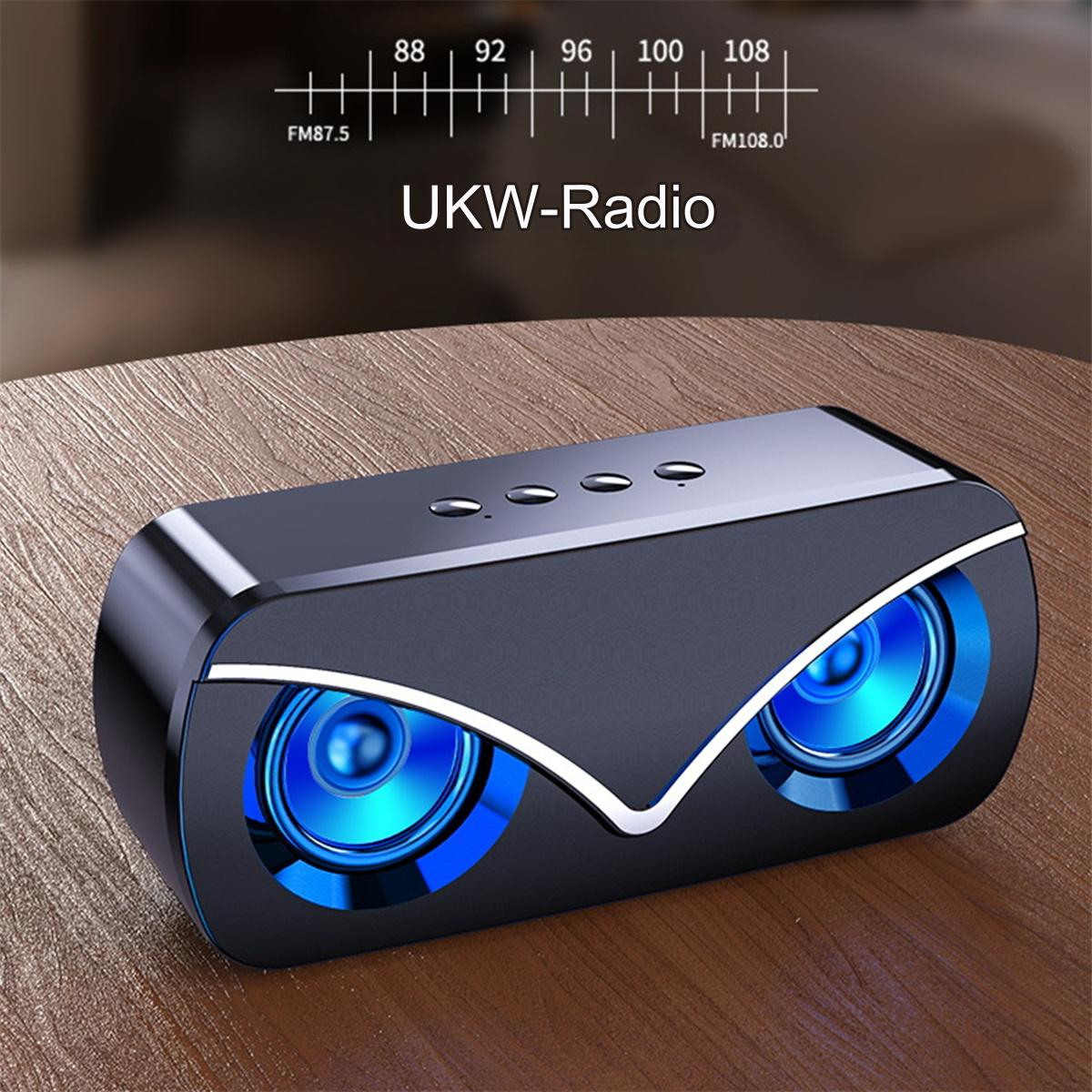 Schwarzer Lautsprecher mit blauen Lichtern um die Lautsprecher, Holztisch, UKW-Radio.